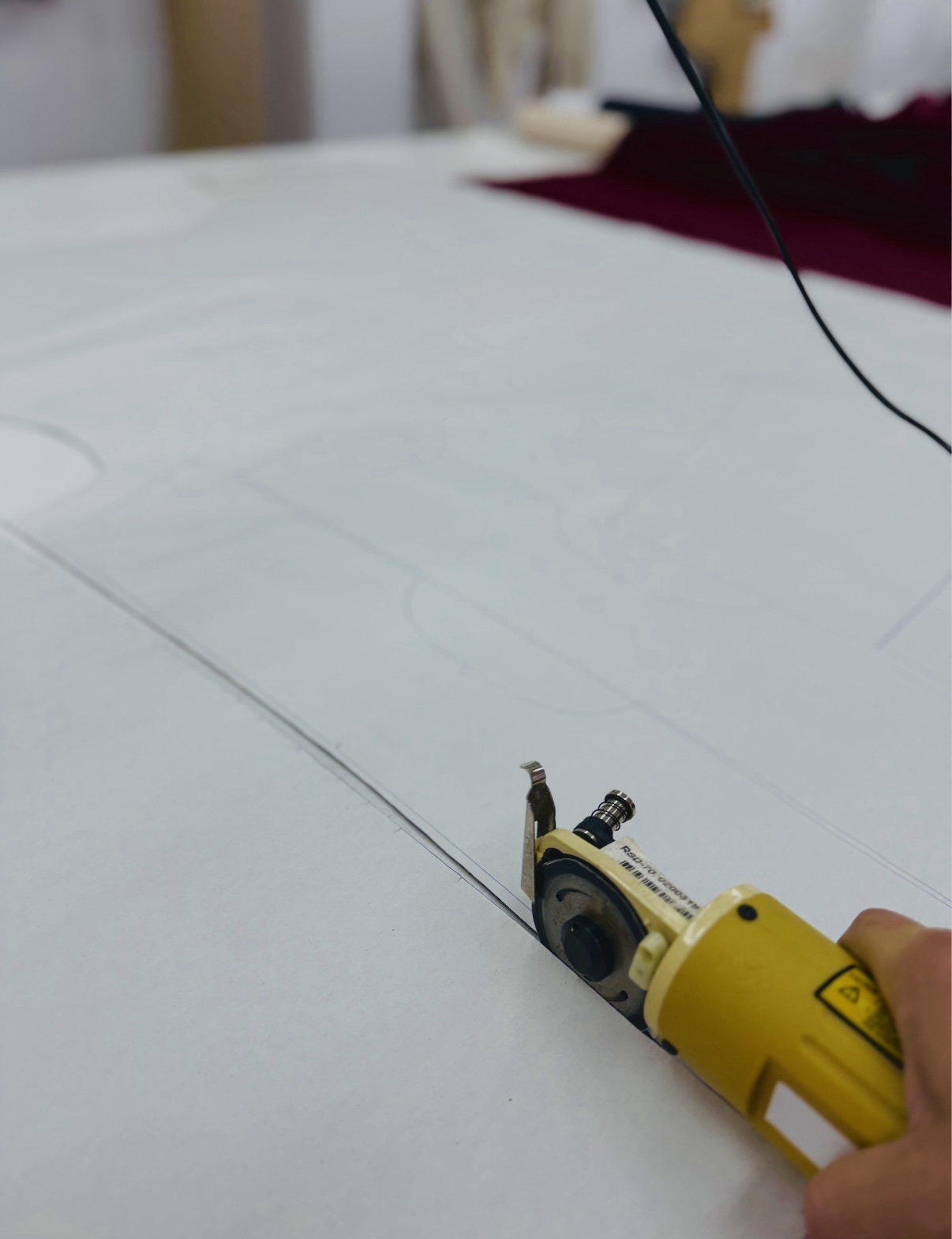 Cutting fabric along pattern lines with electric cutter
